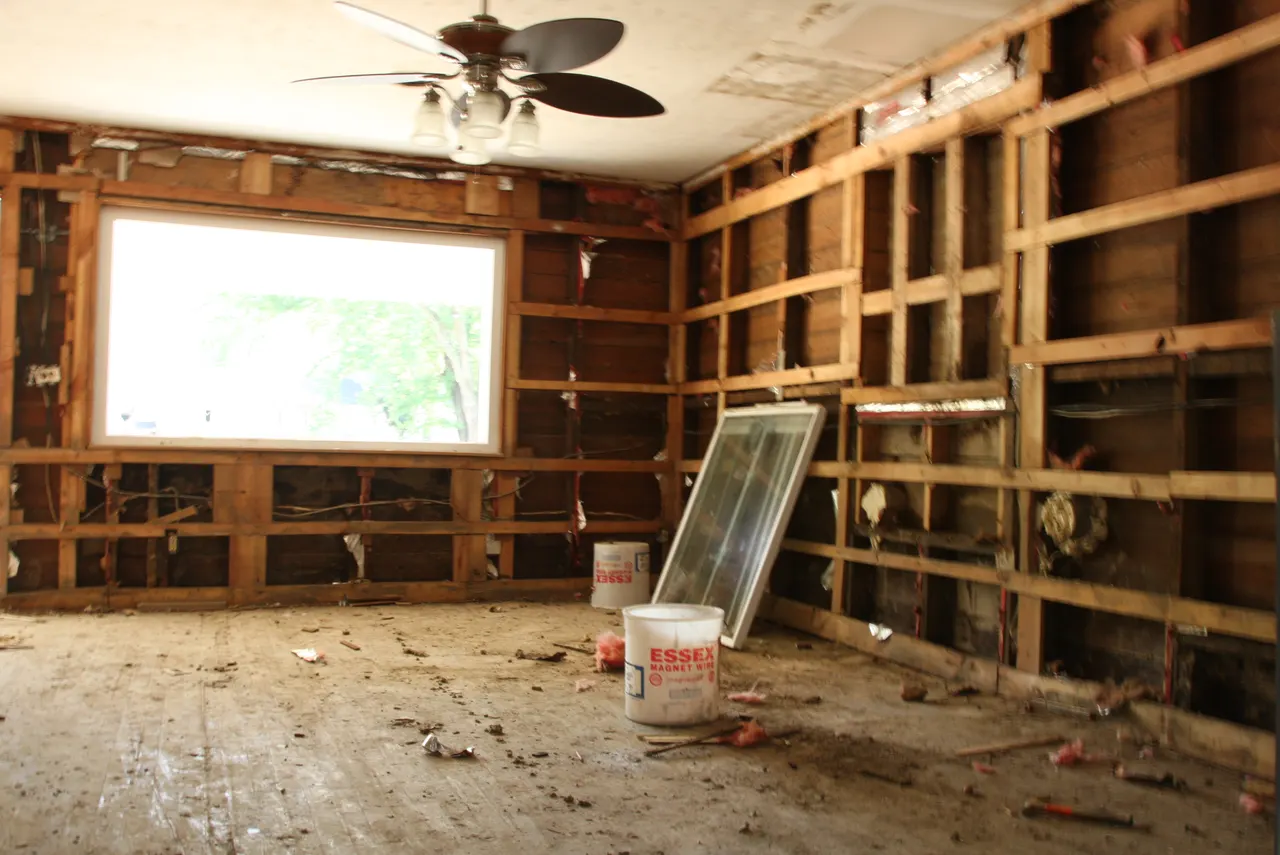 Flood-affected room with exposed wall framing, representative material-assessment context